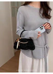 Vista detallada del bolso de mujer con solapa de leopardo y abalorios, elegante accesorio de moda.