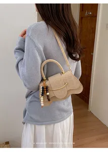 Elegante bolso de hombro estilo retro con un diseño irregular único y cierre metálico elegante.