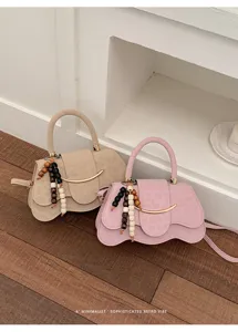 Vista detallada del bolso de hombro moderno con abalorios de madera y diseño retro.