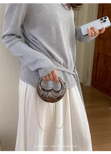 Modische, mondförmige Mini-Handtasche mit Metallfinish und eleganter Kette für Damen.