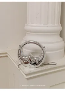Silberne metallische Mini Handtasche Detail mit einzigartigem abstrakten Design mit Kette.