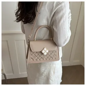 Einfache beige Umhängetasche mit gesteppter Stickerei und elegantem Kleeblatt-Verschluss.