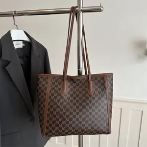 Fashionable brown monogram tote bag featuring double shoulder handles for daily casual use.