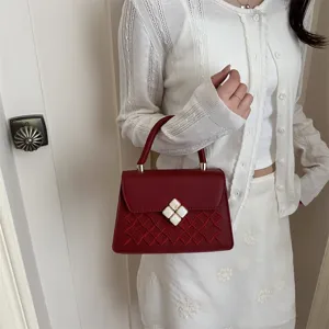 Rote bestickte Mini-Henkeltasche mit elegantem Steppmuster und schickem Kleeblatt-Verschluss.