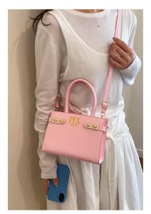 Pink shoulder bag detail view, showing elegant metal hardware and custom letter design.
