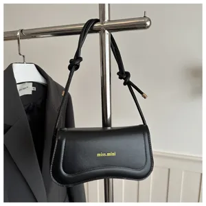 Black French style trendy chic shoulder bag, elegant curved design for daily commute.