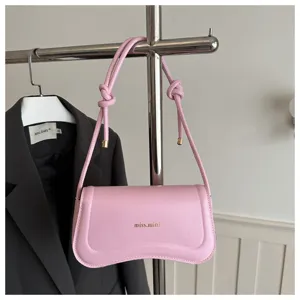 Chic pink leather underarm shoulder bag with curved design and knotted straps for women.