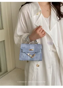 Gros plan sur les ferrures de serrure en métal et la poignée de ce sac à main chic.