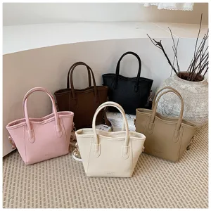 Detail view of stylish minimalist bucket handbags in multiple colors, premium leather texture.