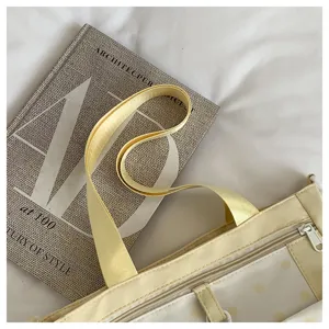 Detailed shot of the yellow crossbody bag featuring durable zipper, wide strap and cute polka dot.