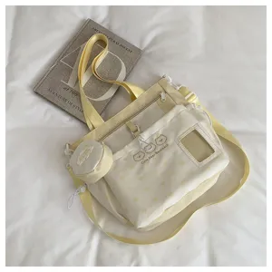 Detail shot of the light yellow polka dot canvas crossbody bag with cute bear embroidery and small pouch.
