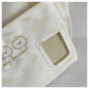 Detailed view of the cute polka dot student crossbody bag with clear window and bear embroidery.