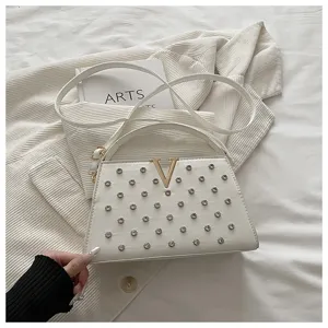 Sac porté épaule en cuir blanc avec logo V doré et rivets pour un style élégant.