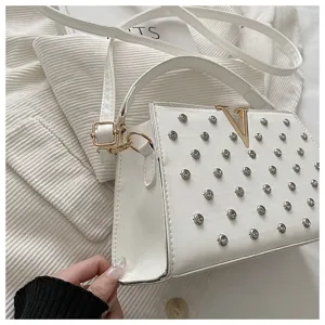 Sac à bandoulière blanc clouté pour femme, sac à main élégant avec logo V doré.