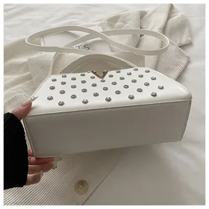 Sac à main bandoulière blanc avec clous métalliques et fermoir V, vue détaillée.
