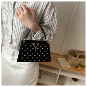Élégant sac à main noir avec des strass scintillants et un fermoir en V tendance.
