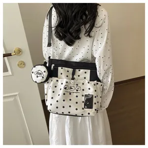 Black and white polka dot backpack detail showing cute bear design and matching coin pouch.