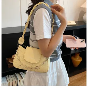 Chic yellow underarm shoulder bag with star pattern and trendy flower chain accessory.