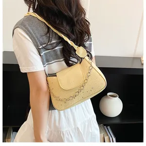Detailed view of trendy yellow leather shoulder bag with chic chain and star pattern.