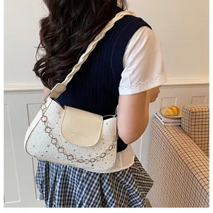 Detail view of stylish white shoulder bag featuring cute star prints and elegant flower chain.