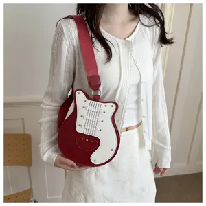 Detail view of creative guitar shaped crossbody bag, stylish red and white color blocking strap.