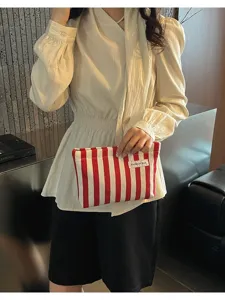 Détail de trousse de maquillage en tissu rayé rouge et blanc, pochette portable.
