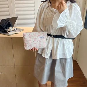Jolie trousse de maquillage rayée à nœud, pochette de voyage élégante en tissu pour femmes.