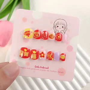Primer plano de lindas uñas postizas infantiles de estilo chino con patrones festivos.