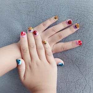 Bonitas uñas postizas infantiles con coloridas mariquitas y corazones, vista de detalle
