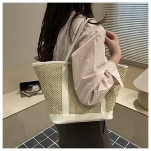 Detailed view of the women's woven straw shoulder bag with contrast white PU leather trim.