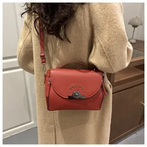 Sac à bandoulière élégant pour femme avec serrure en métal et poignée pour le style.