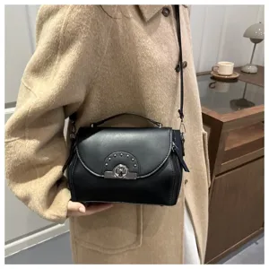 Sac à bandoulière noir chic pour femme, sac en cuir tendance avec serrure métallique et clous.