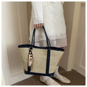 Women straw woven tote bag summer beach shoulder bag with chic beaded tassel and navy leather trim.