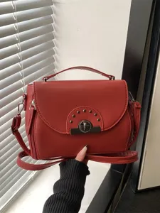 Sac bandoulière élégant pour femme en rouge avec serrure en métal, tendance chic.