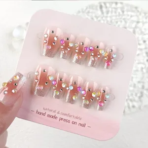 Uñas postizas degradadas blush hechas a mano con pedrería colorida y brillo plateado.