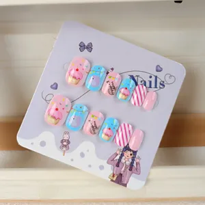 Primer plano detalle de uñas postizas lindas para niños con bonitos diseños de pastelitos.