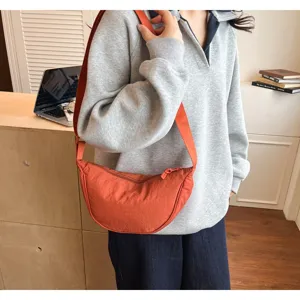 Vista dettagliata della borsa a tracolla a mezzaluna arancione casual, leggera e molto chic.