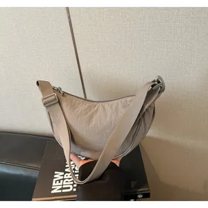 Vista dettagliata di una borsa a tracolla a mezzaluna in nylon, stile casual chic.