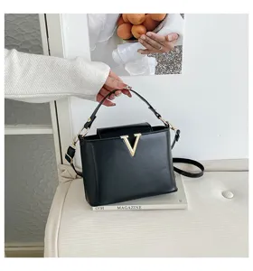 Élégant sac seau en cuir noir pour femme, avec logo V métallique et bandoulière pratique.