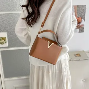 Chic marron sac seau avec decor metal V, elegante sac a bandouliere pour les femmes.