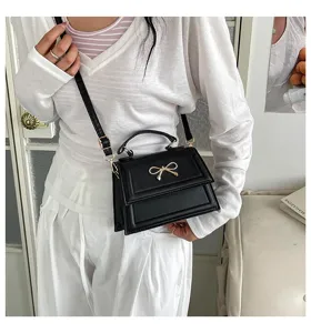 Vue détaillée d'un sac bandoulière noir tendance doté d'un nœud chic pour un style quotidien.