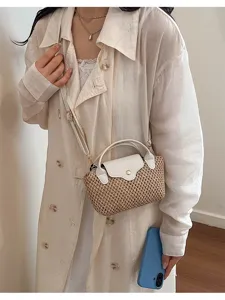 Kleine rieten crossbody tas met witte lederen flap voor een zomerse strandvakantie.