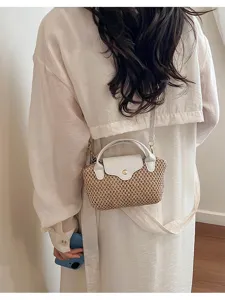 Detailopname van mini geweven strooien crossbody tas met witte lederen flap en handvat.