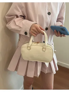 Detailed view of the stylish cream Boston handbag featuring durable leather and chic twin handles.