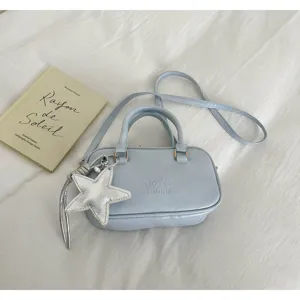 Light blue Boston handbag, stylish casual crossbody purse with silver star charm and handles.
