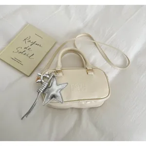 Off-white PU leather Boston handbag detail showcasing silver star charm and debossed logo design.