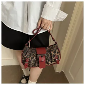 Vista detallada de bolso de hombro con estampado de leopardo y hebilla roja para mujer.