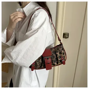 Bolso de hombro chic con estampado de leopardo, ribete de cuero rojo y hebilla moderna.