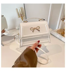 Petit sac bandoulière blanc pour femme vue de détail avec accessoire nœud papillon doré.