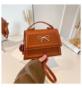Sac à main carré marron élégant pour femme avec nœud doré et bandoulière chic et tendance.